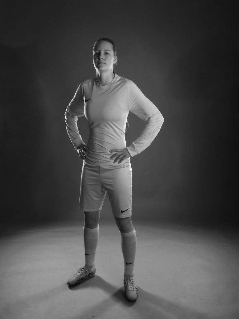 Wiktoria, gardienne de football, debout en studio, portrait en noir et blanc.