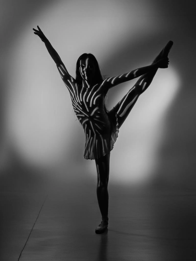 Danseuse en développé à la seconde, pose dynamique bras ouverts