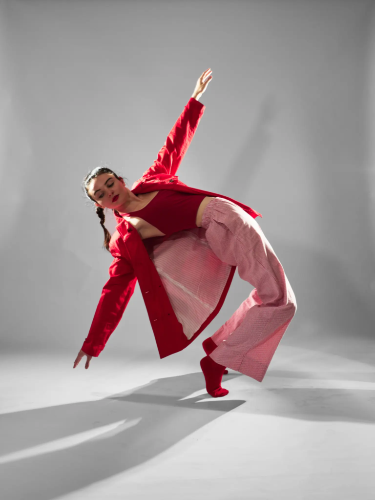 Danseuse en diagonale, veste et pantalon rouges, photo studio