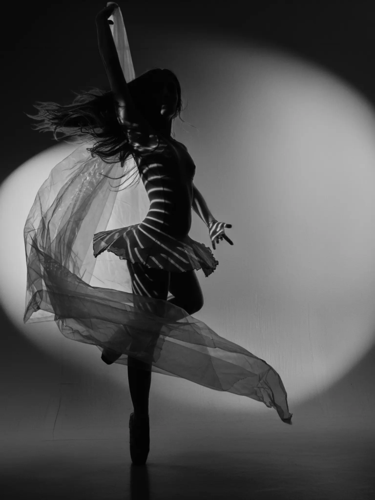 Danseuse avec voile en mouvement et cheveux au vent, photographie artistique
