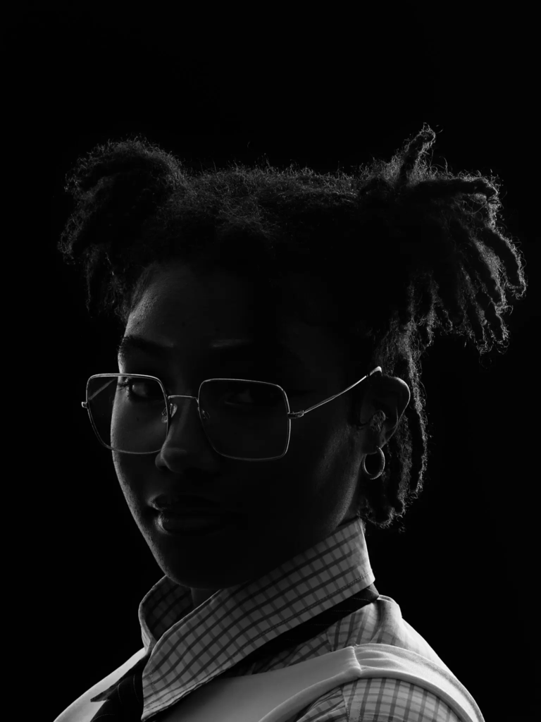 Portrait en clair-obscur d'une femme aux cheveux en locks et lunettes, photographe portrait Beauchamp
