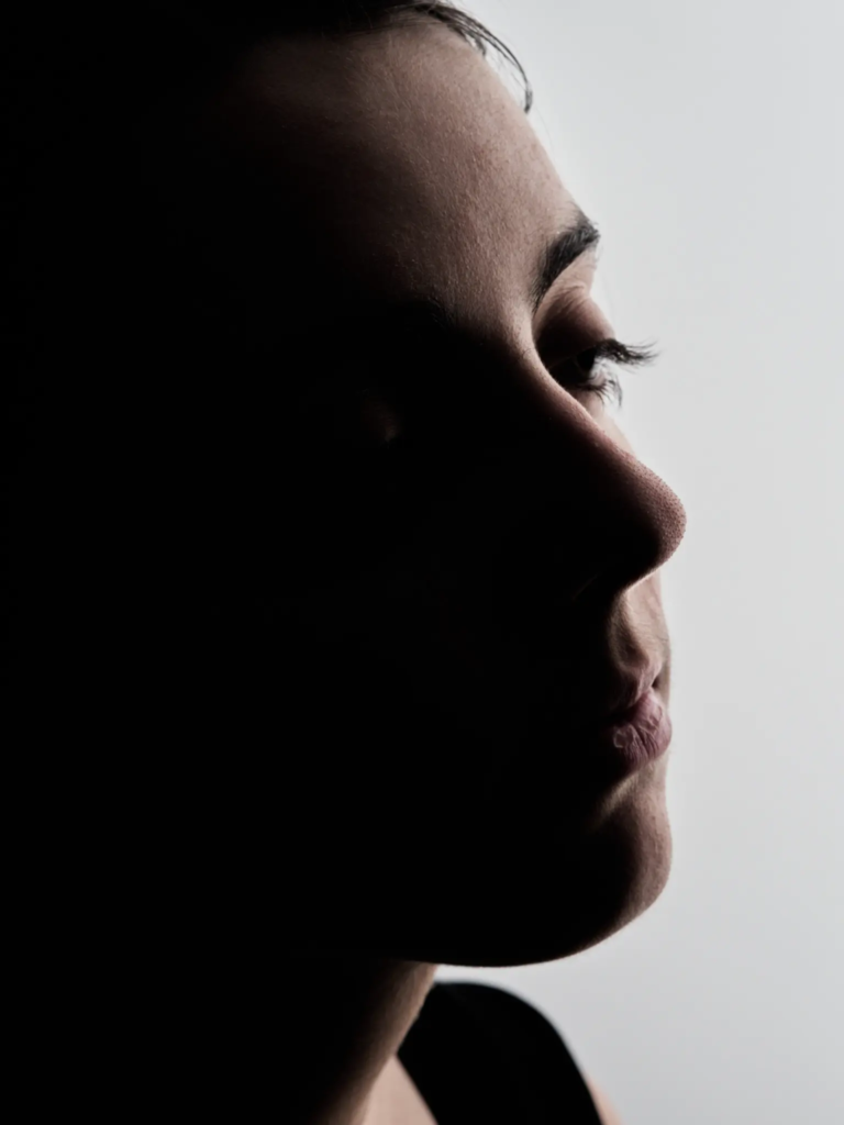 Profil minimaliste sur fond clair, dégradé de lumière sur le visage